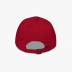 A red baseball cap viewed from the back, featuring an adjustable strap with a black plastic buckle, set against a plain light gray background.