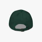 A spruce green baseball cap viewed from the back, featuring an adjustable strap with a brown plastic buckle, set against a plain light gray background.