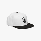 White and black snapback cap with a black embroidered 'OR' logo on the front, set against a plain light gray background.