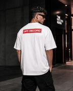 Person wearing a white Off-Record reverse stamp tee logo t-shirt with 'OFF-RECORD' logo on the back, standing in an urban setting.