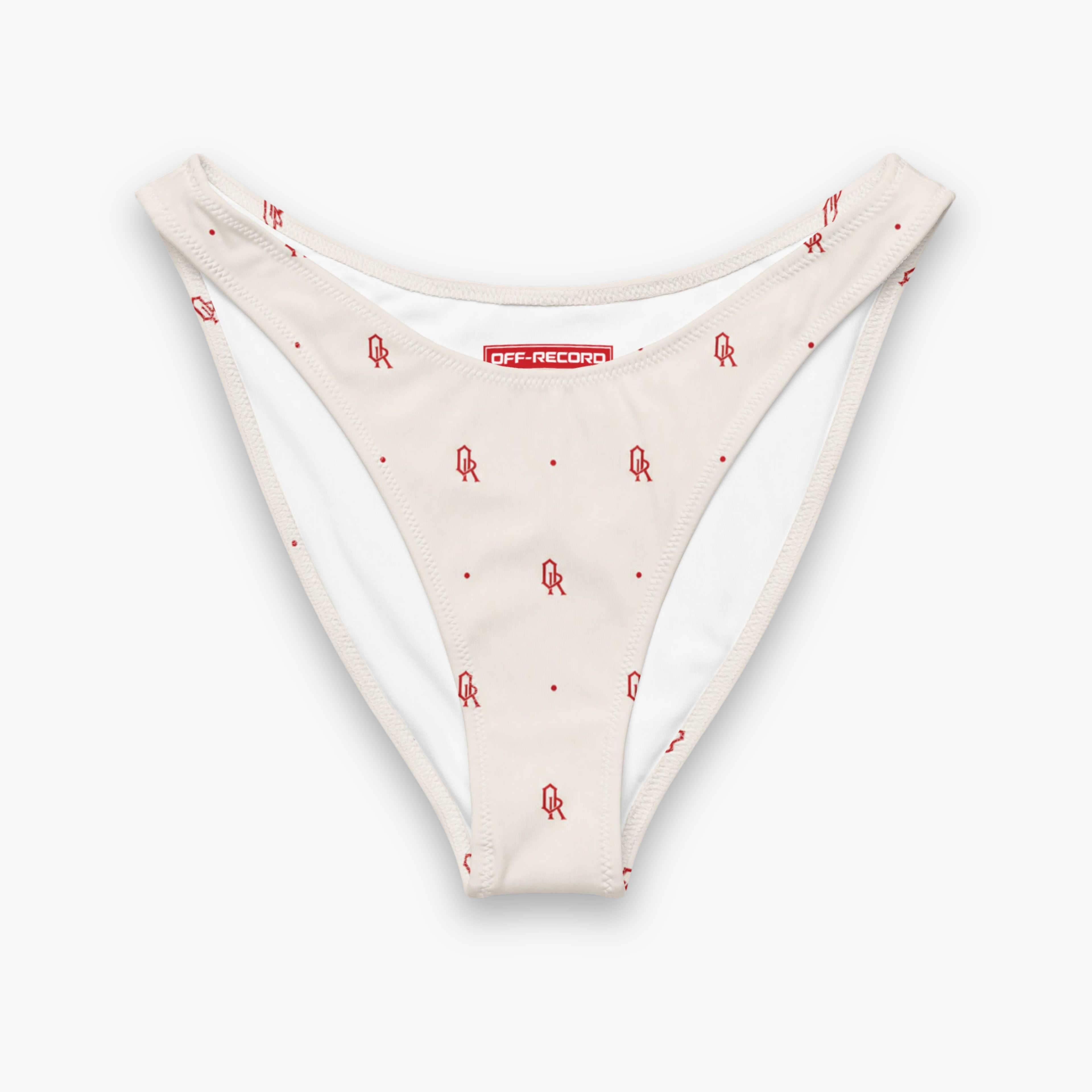 A pair of low-rise bikini bottoms in a warm cream color, featuring a small red graphic print of a stylized figure and a red dot pattern throughout. The brand name 'off-record' is printed in white on a red label at the center front.